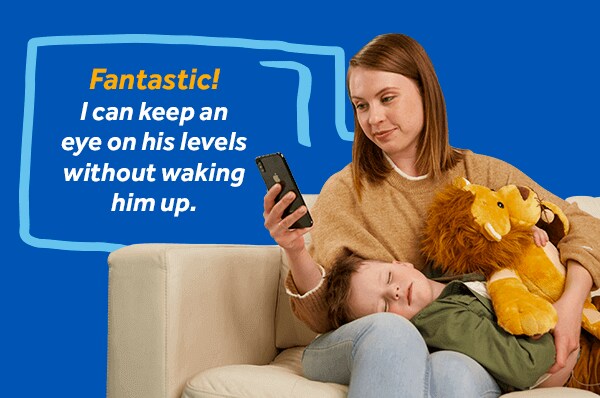 Image of a mom checking her sleeping son’s sugar levels on her smartphone