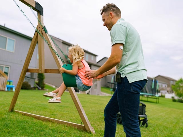 Simplera Sync on man with daughter on the swing