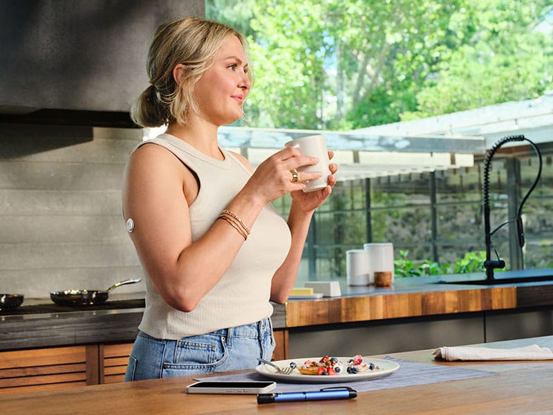Woman holding a cup in the kitchen