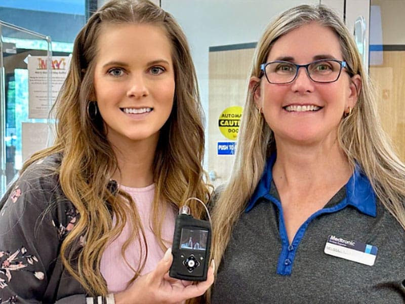 Two women holding MiniMed insulin pump