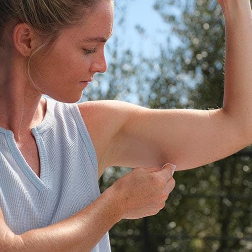 Woman wiping her arm with alcohol wipe