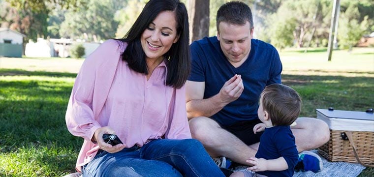 Image of family and a mother checking her insulin pump