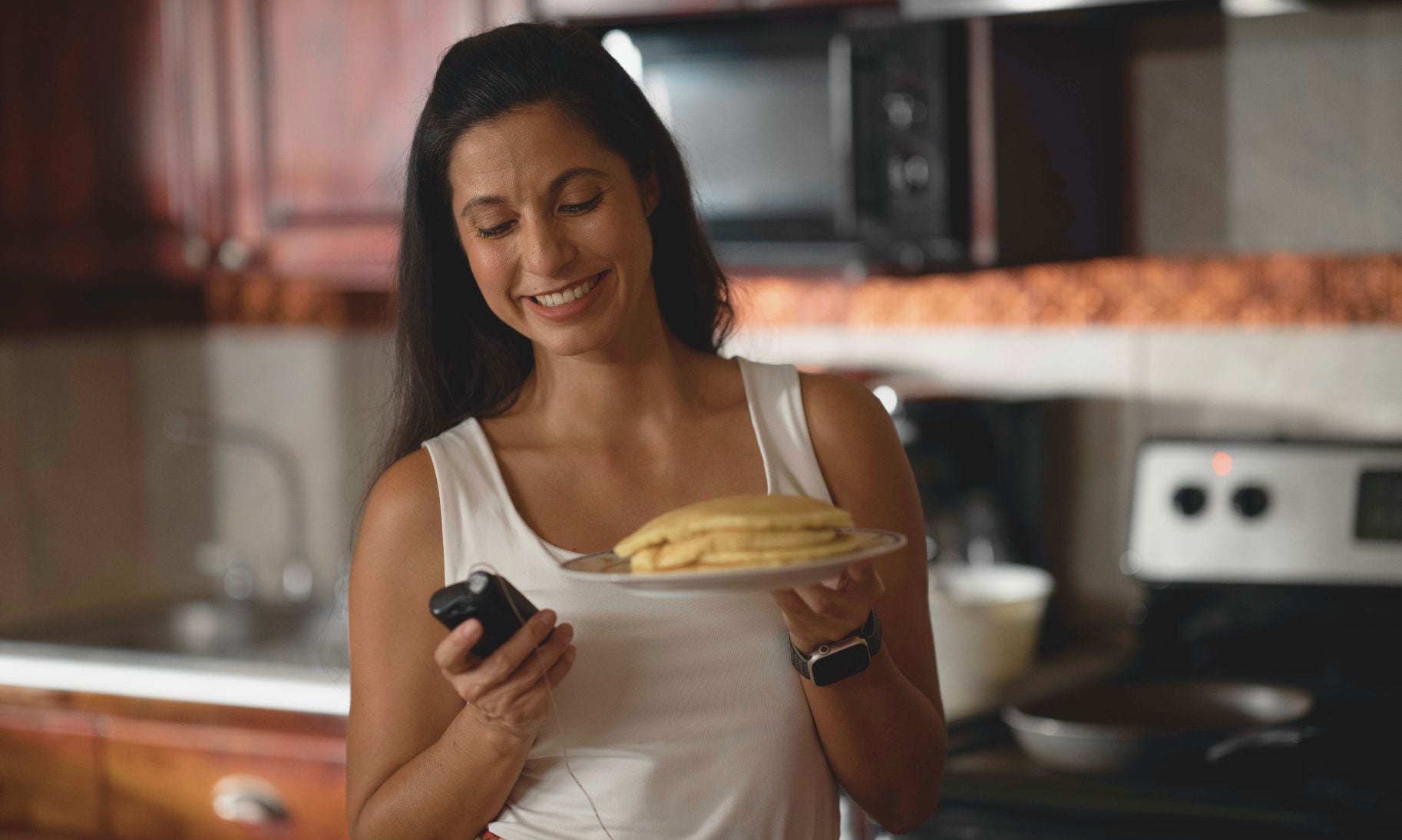 Woman holding pancakes and MiniMed 780G system