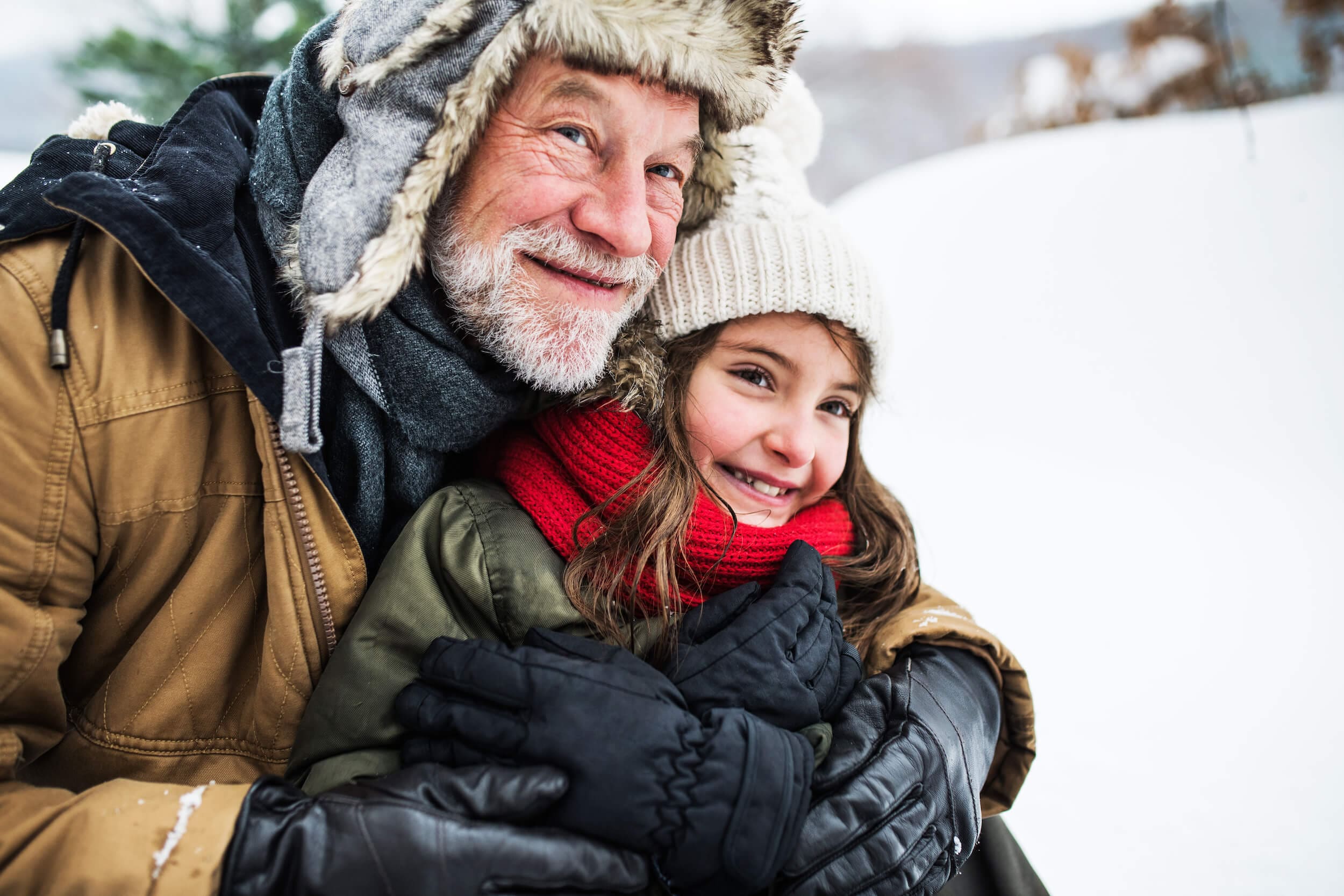 Older man with young girl in the snow
