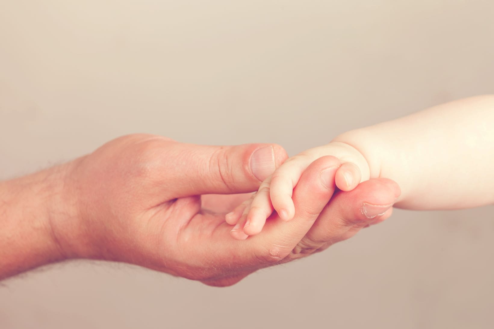 father and baby hands holding
