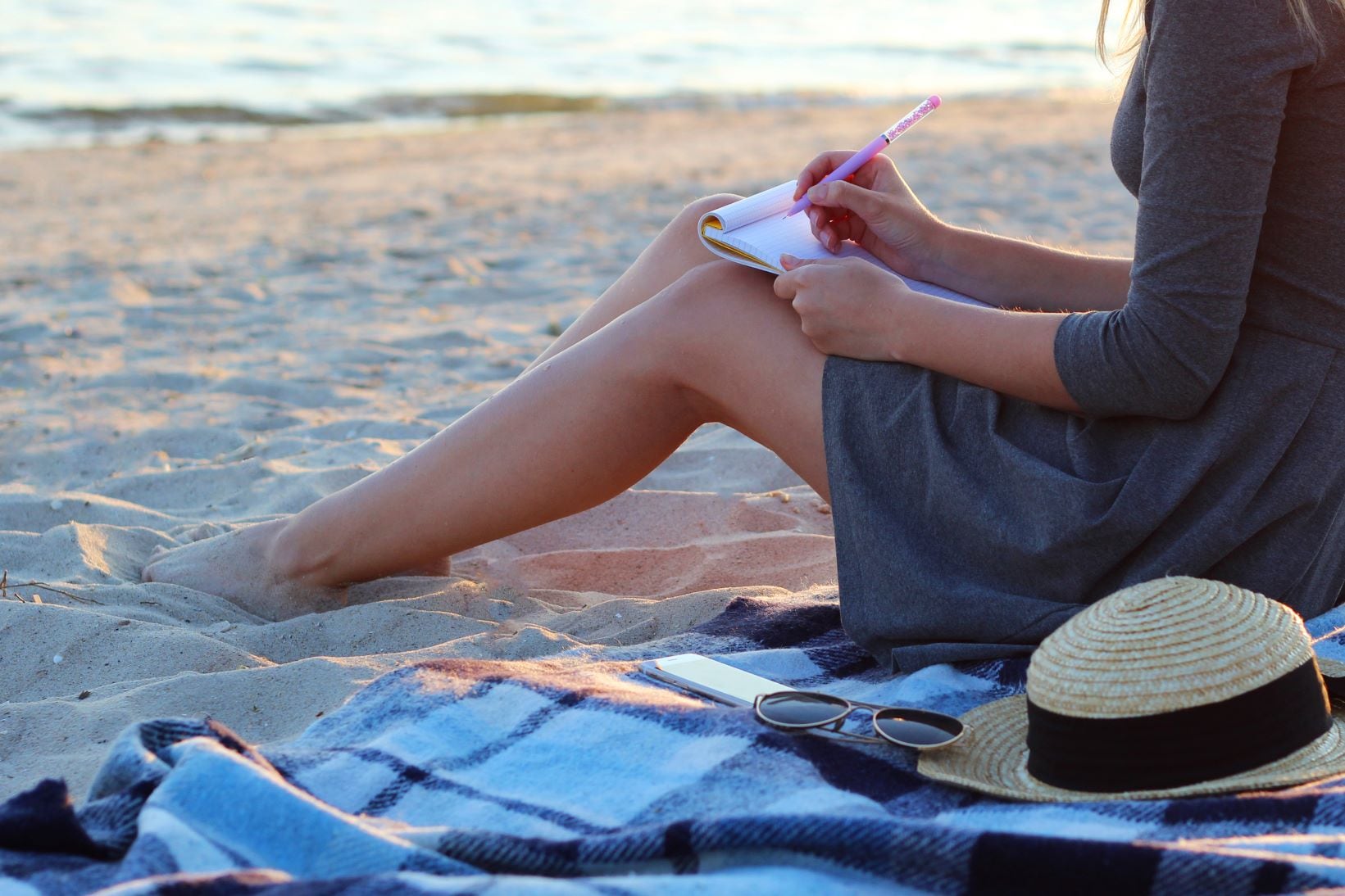 woman writing on the beach