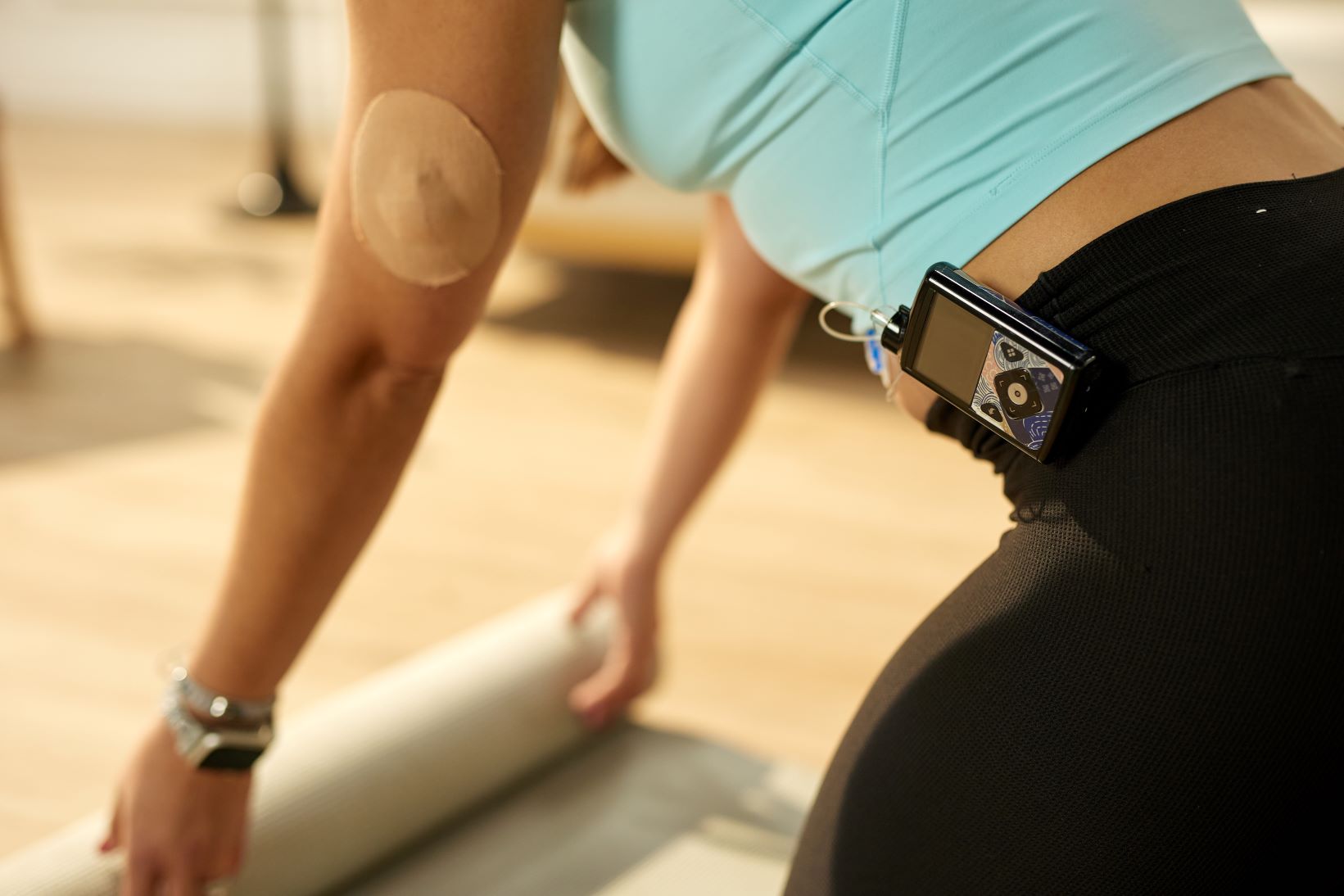 woman with insulin pump and yoga mat